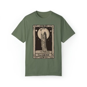 Op de afbeelding: Een groen T-shirt met een vintage tarotkaartontwerp met een vrouw die een kelk vasthoudt. De kaart is gelabeld met "VIII The BRIDE".