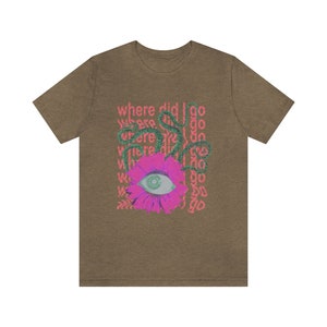 May include: A brown t-shirt featuring a pink flower with a green eye in the centre. The text "where did I go" is repeated in pink around the flower.