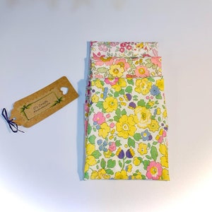 May include: A stack of four fabric squares with a floral pattern in shades of pink, yellow, and green. The fabric squares are folded neatly and have a white background. A small brown tag with the text "C's Crafts & Handmades" is visible in the image.