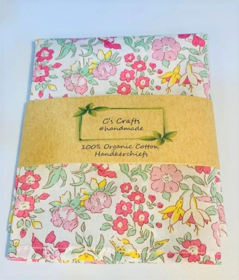 May include: A white cotton handkerchief with a pink and green floral pattern. The handkerchief is folded and wrapped in brown paper with the text "C's Crafts #handmade 100% Organic Cotton Handkerchiefs".