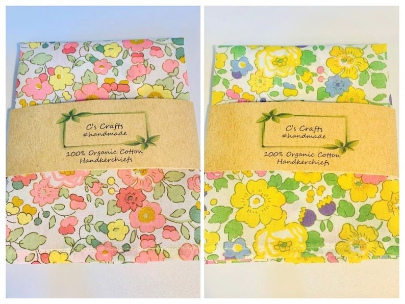 May include: Two floral handkerchiefs with a white background and colorful flowers. The handkerchiefs are packaged with a brown paper label that reads "C's Crafts #handmade 100% Organic Cotton Handkerchiefs".