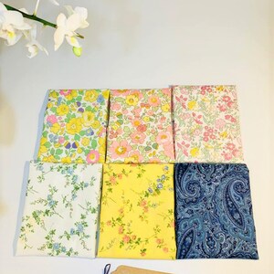 May include: Six fabric squares with different floral and paisley patterns. The fabrics are in shades of yellow, pink, blue, and white. A small brown tag with the text "C's Craft #handmade" is in the bottom right corner.