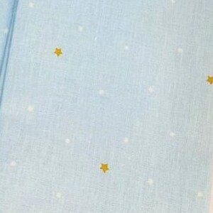 May include: A light blue fabric with a white and gold star pattern.