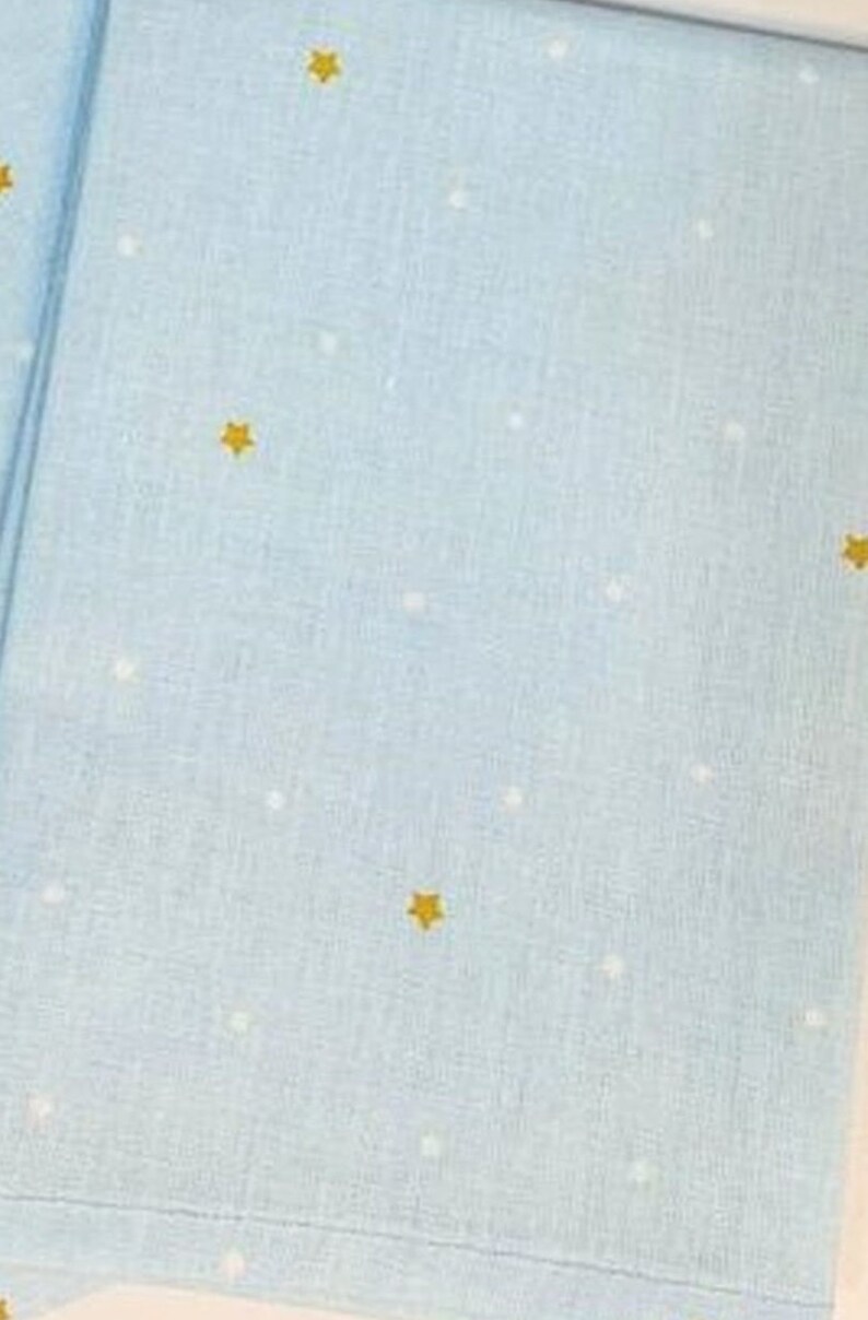 May include: A light blue fabric with a white and gold star pattern.