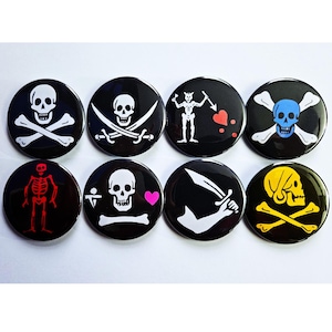 May include: Eight black round buttons with various pirate-themed designs. The designs include skulls with crossbones, swords, and hearts, in white, blue, red, and yellow. The buttons are arranged in two rows of four.