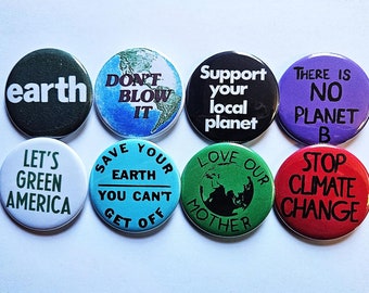 Puede incluir: Ocho botones redondos con varios lemas ambientales impresos en ellos. Los lemas incluyen "earth", "Don't Blow It", "Save Your Earth You Can't Get Off", "Support Your Local Planet", "There Is No Planet B", "Let's Green America", "Love Our Mother", y "Stop Climate Change".