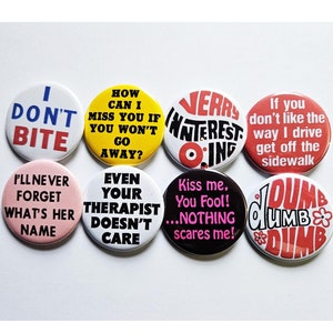 Puede incluir: Nueve pines de botón redondos con diferentes frases humorísticas en texto negro, blanco, rojo, rosa, amarillo y azul sobre fondos blanco, amarillo, rosa, rojo y negro.