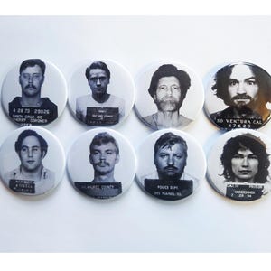 May include: Eight black and white mugshots of men on round white buttons. The buttons have text on them, including dates, locations, and the words "Santa Cruz Coroner", "Ventura Cal", "Police Dept", and "Des Plaines, Ill".
