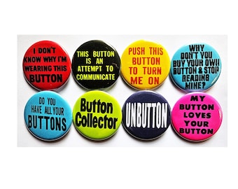 Puede incluir: Ocho chapas redondas dispuestas en dos filas. Las chapas son de color rojo, negro, amarillo, azul claro, azul medio, verde lima, azul oscuro y rosa, cada una con texto en negro o blanco con frases como I DON'T KNOW WHY I'M WEARING THIS BUTTON.