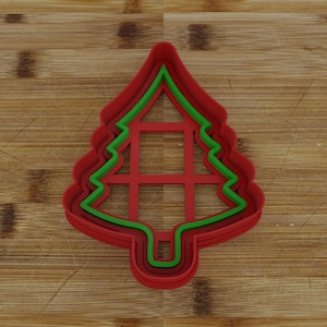 May include: A set of three red and green plastic Christmas tree cookie cutters. The cutters are layered on top of each other, with the largest cutter on the bottom and the smallest cutter on top.