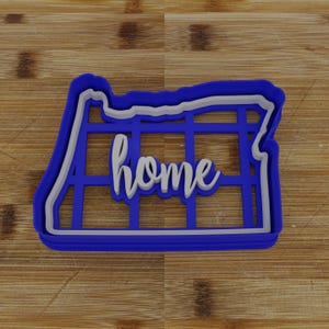 May include: Blue plastic cookie cutter shaped like the state of Oregon with the word "home" inside.