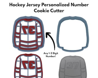Może przedstawiać: Zestaw foremek do ciastek w kształcie koszulki hokejowej. Foremki są szare i czerwone, z napisem "Hockey Jersey Personalized Number Cookie Cutter" u góry. Obrazek przedstawia również szare ciastko z numerem 37.