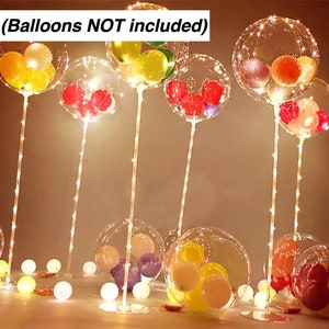 Pode incluir: Bal&otilde;es de pl&aacute;stico transparente com luzes de corda no interior, dispostos em suportes. Os bal&otilde;es est&atilde;o cheios de bal&otilde;es menores coloridos. O texto (Balloons NOT included) &eacute; vis&iacute;vel na parte superior da imagem.