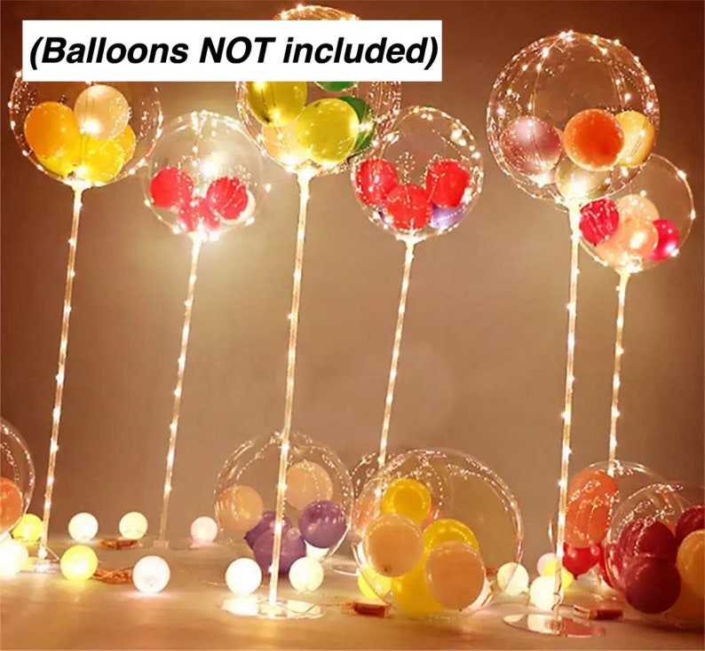 Pode incluir: Bal&otilde;es de pl&aacute;stico transparente com luzes de corda no interior, dispostos em suportes. Os bal&otilde;es est&atilde;o cheios de bal&otilde;es menores coloridos. O texto (Balloons NOT included) &eacute; vis&iacute;vel na parte superior da imagem.