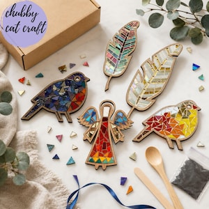 May include: A mosaic craft kit featuring two bird shapes, two feather shapes, and one angel shape with wooden outlines. The kit includes colorful glass tiles, two wooden spoons, a bag of dark grout, and a cardboard box labeled chubby cat craft.