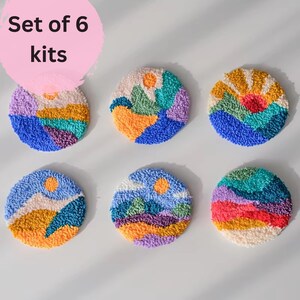 May include: Set of six colorful punch needle kits featuring abstract landscape designs with mountains, sun, and clouds. Each kit is a round, white canvas with pre-punched holes.