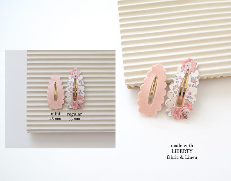 May include: Two pink hair clips with scalloped edges. The larger clip is 5.5 inches and features a floral print fabric. The smaller clip is 4.5 inches and is solid pink. The text "made with LIBERTY fabric & Linen" is printed below the clips.