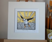 Puffin at sunset, original, hand coloured, mounted lino print