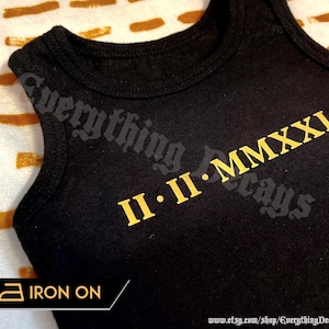 Könnte beinhalten: Ein schwarzes ärmelloses Shirt mit goldener Bügelfolie, auf dem "II.II.MMXXI Everything Decays" steht.