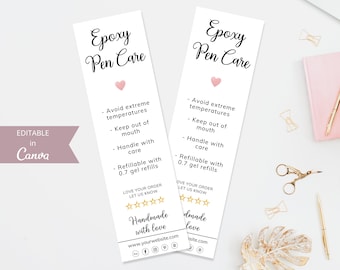 May include: Two white bookmark-style cards with black text that reads "Epoxy Pen Care". The cards have a pink heart and list care instructions for epoxy pens. The text includes "Avoid extreme temperatures", "Keep out of mouth", "Handle with care", and "Refillable with 0.7 gel refills". The cards also have a five-star rating and the text "Handmade with love" and a website address.