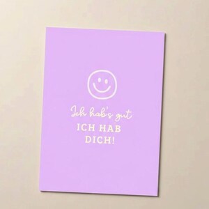 Könnte beinhalten: Eine lavendelfarbene Grußkarte mit einem weißen Smiley und dem deutschen Text "Ich hab's gut, ICH HAB DICH!". Die Karte hat ein schlichtes, klares Design, ideal für eine positive Botschaft.