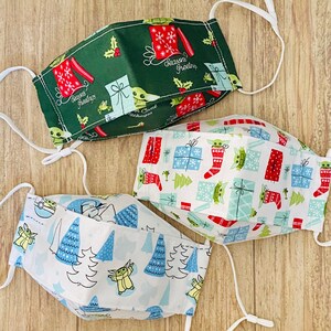 The “Child” and Mando 3D Face Masks in “Green” OR “Child With Presents” OR “Child with Trees” Print Cotton Fabric