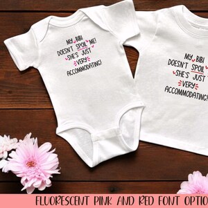 May include: Two white baby onesies with black text that reads "My Bibi doesn't spoil me! She's just very accommodating!"  The text is in a pink and red font.