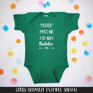 May include: Green baby onesie with white text that reads "PLEASE PASS ME TO MY BUBBE" with a small arrow and heart design.