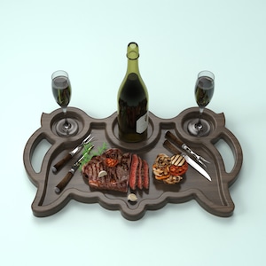 May include: A wooden serving tray with two glasses of red wine, a bottle of wine, a steak, grilled vegetables, and two steak knives.