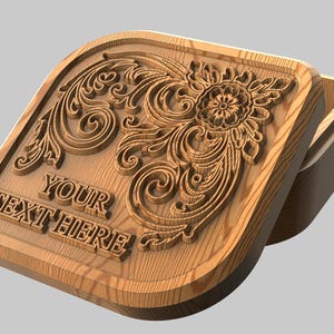 Könnte beinhalten: Eine hellbraune Holzbox mit einem geschnitzten Blumendesign und dem Text "YOUR TEXT HERE". Die Box hat einen Klappdeckel. Das florale Design umfasst eine zentrale Blume und wirbelnde Muster.