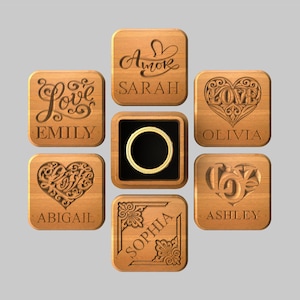 Könnte beinhalten: Holzringboxen mit eingravierten Namen und Herz- oder Blumendesigns. Die Namen Emily, Sarah, Olivia, Abigail, Sophia und Ashley sind abgebildet. Eine zentrale Box enthält einen goldenen Ring.