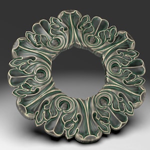 May include: A decorative metal ring with a detailed floral design in shades of green and silver.