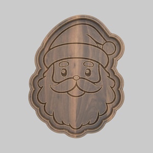 May include: Wooden Santa Claus face carving. The carving features a detailed depiction of Santa's face, including his hat, eyes, mustache, and beard. The wood has a natural grain and a warm, brown tone. The carving is likely for holiday decor.