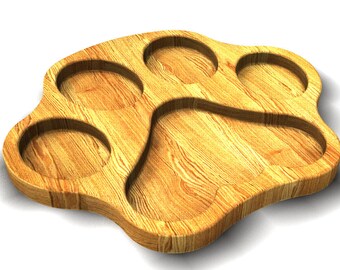 May include: A wooden serving tray shaped like a paw print with four individual indentations. The tray is made of light brown wood with a natural wood grain.