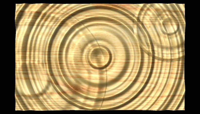 Puede incluir: Primer plano de una superficie de madera con un patr&oacute;n circular de anillos conc&eacute;ntricos, que se asemejan a las ondas en el agua. La madera tiene un color marr&oacute;n claro con vetas marrones m&aacute;s oscuras.