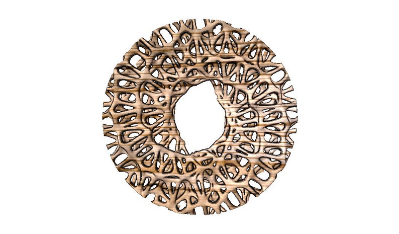 May include: A circular wooden wall decoration with an intricate, laser-cut design. The design features a repeating pattern of organic shapes, creating a delicate and airy look. The wood is a light brown colour, with a natural grain visible.