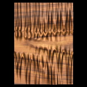 Peut inclure: Gros plan sur une texture de bois avec un motif répétitif d'arches et de pics. Le bois est de couleur brun clair avec des stries brun foncé.