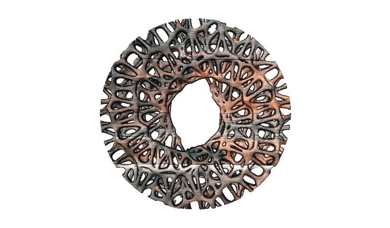 May include: A circular, intricate metal design with a large hole in the centre. The metal is a mix of silver and brown, with a textured, almost wood-like appearance.