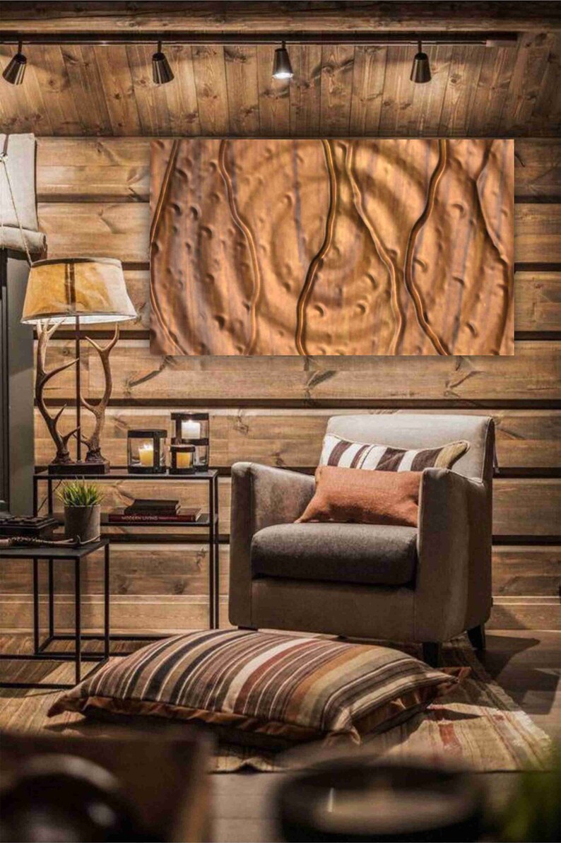 May include: A brown leather armchair with a striped throw pillow and a brown throw pillow sits in a room with wood paneling and a large abstract painting on the wall.
