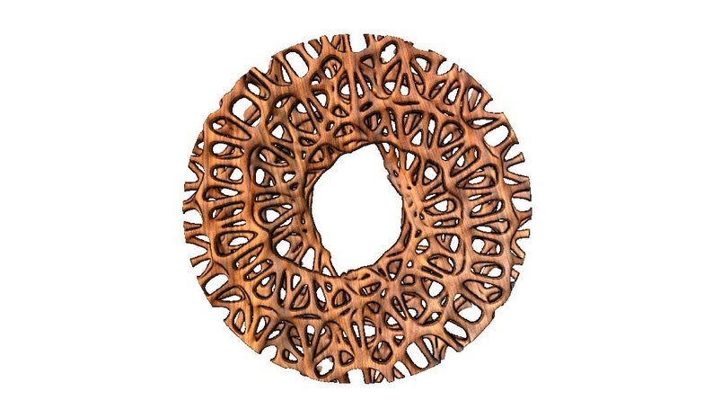 May include: A circular wooden wall decoration with an intricate, lacy design. The decoration is brown and has a large hole in the centre.