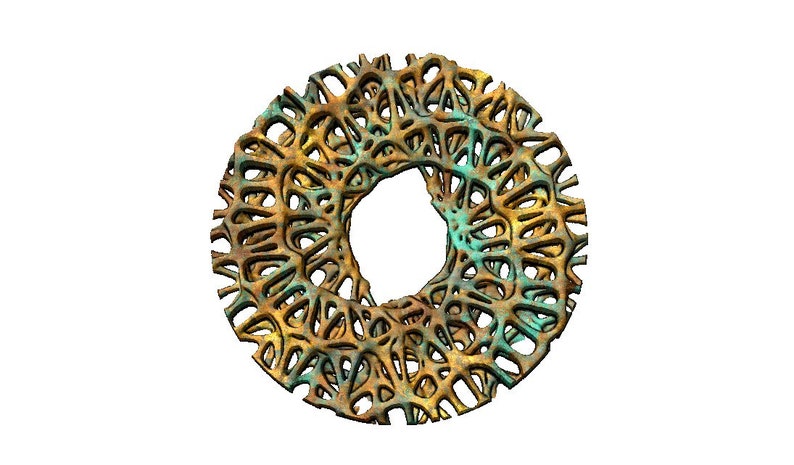 May include: A circular, gold-coloured metal object with an intricate, lacy design. The object has a hole in the centre and is reminiscent of a decorative wheel or gear.