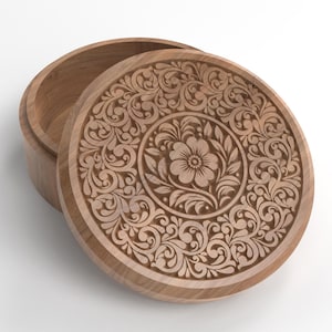 May include: A wooden round box with a lid, partially open. The lid and the box are made of light brown wood. The lid features an intricate floral and scroll design carved into the wood. The box is on a white background.