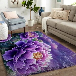 May include: A rectangular area rug featuring a large floral design with purple and pink peony blossoms. The rug has a soft, plush texture and is placed in a living room setting with a gray sofa and armchair.