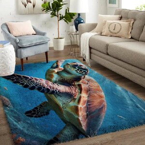 May include: A blue area rug with a detailed image of a sea turtle. The turtle has a brown and green shell, with its flippers extended. The rug has a soft, plush texture, and the background is a deep blue.