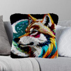 May include: A colorful, pixelated wolf's head with a blue and green moon behind it. The wolf's fur is a mix of white, orange, and red. The image is a throw pillow.