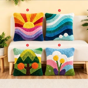 May include: Four square punch needle throw cushions with textured designs. Cushion 1 features a sun and rainbow. Cushion 2 shows blue waves. Cushion 3 displays a tree with orange fruit. Cushion 4 depicts flowers, hills, and a star. Each cushion is numbered.