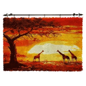 Puede incluir: Un tapiz que representa una puesta de sol sobre una sabana africana con una silueta de un árbol y tres jirafas en primer plano.