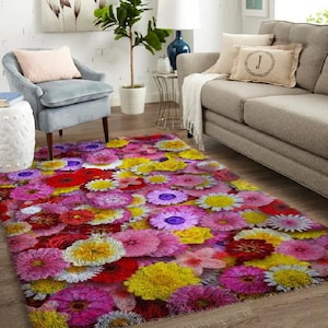 Puede incluir: Una alfombra colorida con un patrón floral que presenta flores rosas, amarillas, rojas y moradas. La alfombra está hecha de un material suave y mullido y tiene una textura peluda.
