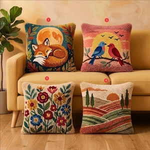 May include: Four square throw pillows featuring textured punch needle embroidery. One displays a sleeping fox under a moon, another shows two birds on a branch, the third features colorful flowers, and the fourth depicts a landscape with trees and a sun.