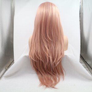 May include: A long, straight, light pink wig with a slight wave. The wig is styled with a center part and falls to the shoulders.